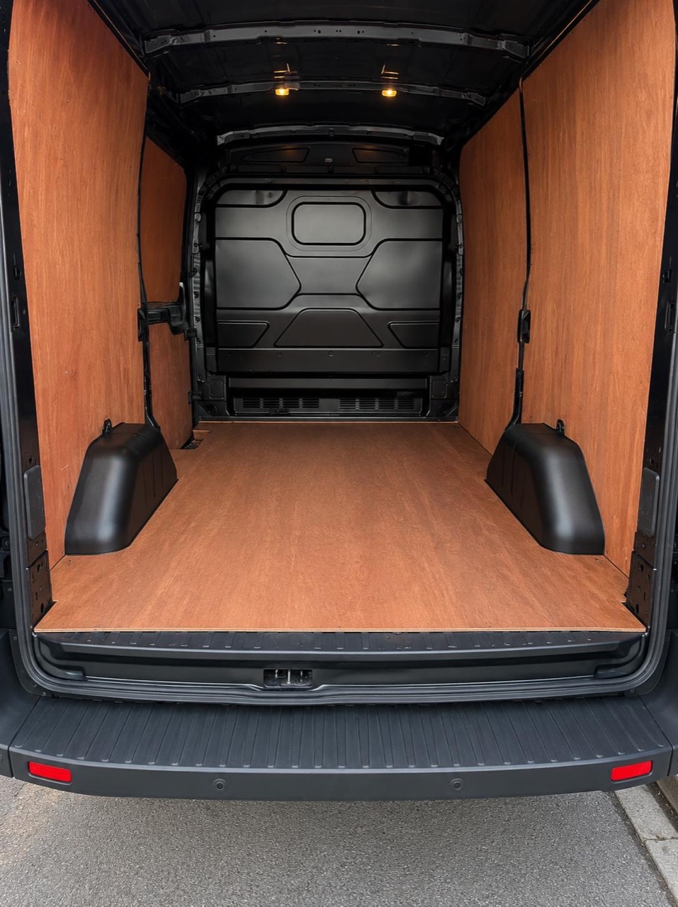 Clean, empty and wood-lined cargo area of the van ready for loading