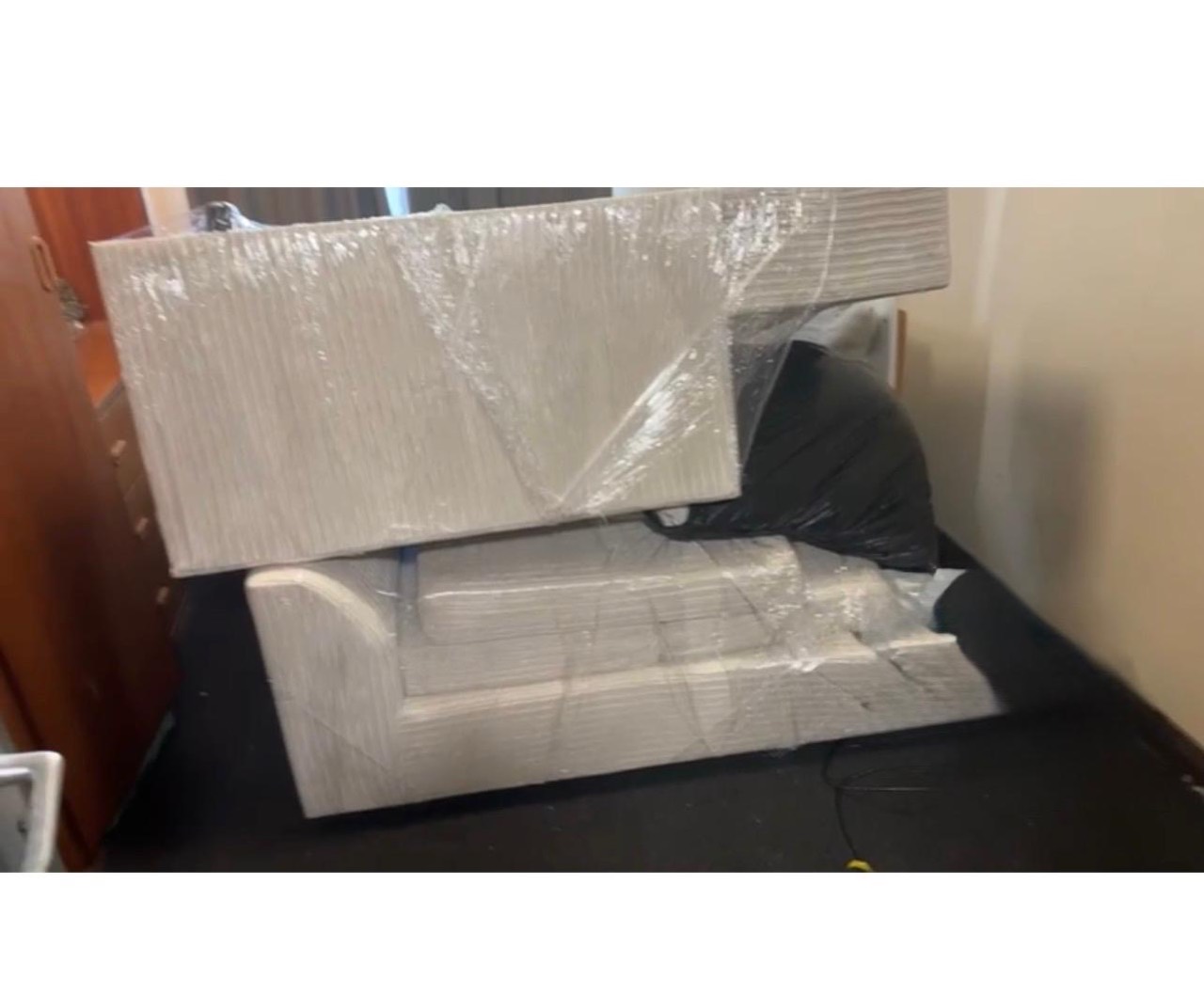 Large furniture pieces wrapped in protective film before moving
